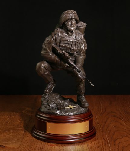 This is an 12" scale cold cast bronze sculpture of a Airborne Forces Combat Medic in an alert pose. We include this standard wooden base and choice of badge. We also offer an engraved brass plate as standard.