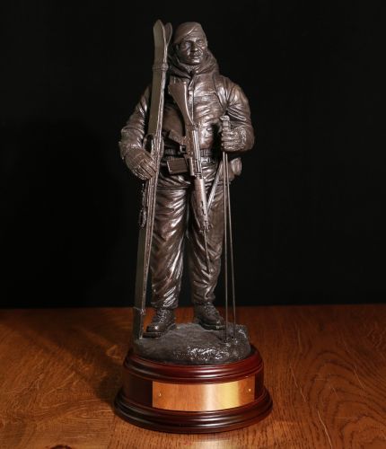 12" scale cold cast bronze sculpture of an Arctic Warfare British Army Soldier with SLR and wearing a Beret. We include a personalized engraving plate and military badge on the base if requested. 