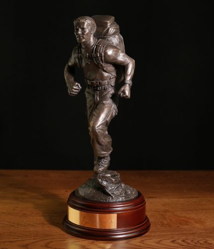This is a sculpture of an British Army Physical Training Instructor leading a route march. 12" Scale sculpture, we can add a cap badge , a choice of wooden base and an optional free engraved brass plate.