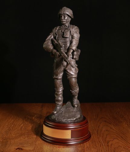 A British Soldier, 12" tall on a short clearance patrol in Afghanistan (OP Herrick) or Iraq (Op Telic) armed with SA80 and Osprey Body Armour, a brass engraved plate is included. We offer a choice of bases, added cap badge and free engraving