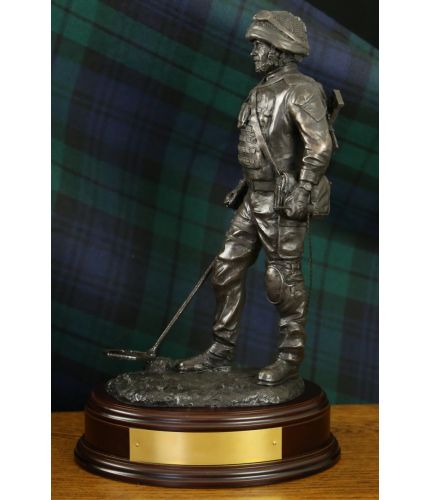 Sculpture depicts a British Army Soldier sweeping for Explosive Ordnance Devices with a Vallon Mine Detector. We include this wooden base as standard, and you can also add a badge and engraving plate free of charge.