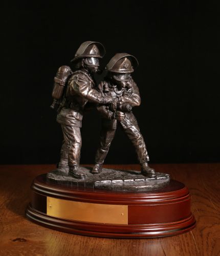 This Fire and Rescue statuette is made in an eight inch scale and it is called 'The Branch'. It depicts a pair of firefighters directing a high pressure jet of water at the seat of a blaze. We offer a choice of wooden base and an engraved brass plate