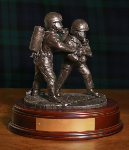 A pair of 8" scale Firefighters tackling a fire on a branch wearing modern Cromwell F600 helmets. We include this wooden base as standard and an optional free brass engraved plate