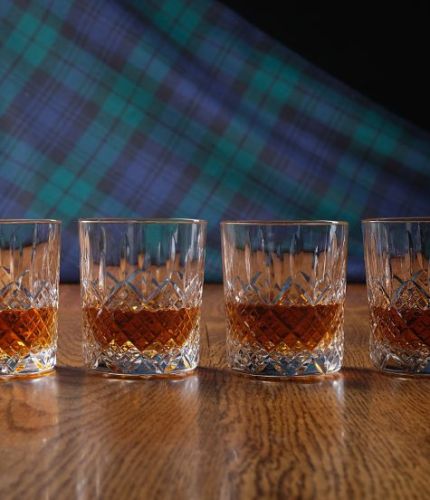 A fully cut whisky crystal hosting set consisting of four tumblers. The set is presented inside a dark blue satin lined presentation box.
