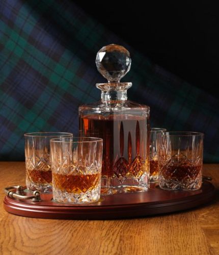 A 24% lead crystal fully cut square decanter and four fully cut whisky tumblers on a serving tray. We can offer a personalised brass plate on the wooden tray with this set.
