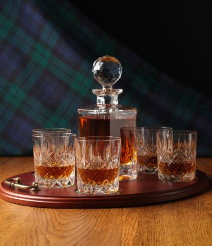 A mixed style of whisky crystal serving tray set consisting of a Decanter and six tumblers. We offer free engraving in the front panel of the decanter and a brass plate on the tray. The set is completed inside a dark blue satin lined presentation box.