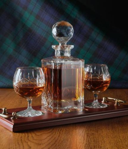 A 24% lead crystal panel cut square decanter and two panel cut brandy goblets on a serving tray. We can offer a personalised engraving on the front of the decanter, goblets and an engraved brass plate on the wooden tray with this set.