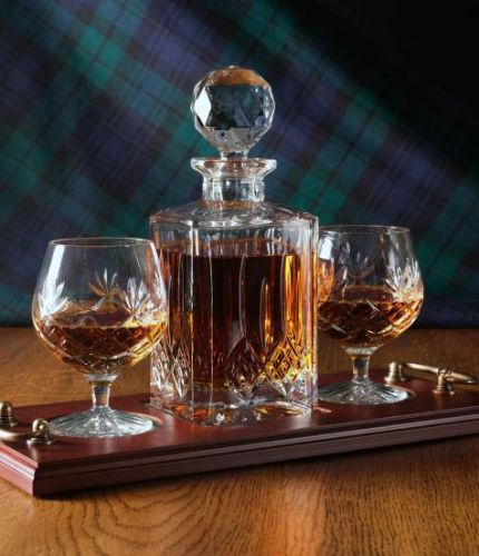 A 24% lead crystal fully cut square decanter and two brandy goblets on a serving tray. We can offer a personalised engraving on a engraved brass plate on the wooden tray with this set.