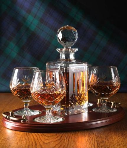 Cut crystal cognac tray set with a decanter and four goblets on a brass handled tray. The set comes in luxurious gift boxes and can include an engraved brass plate on the tray.