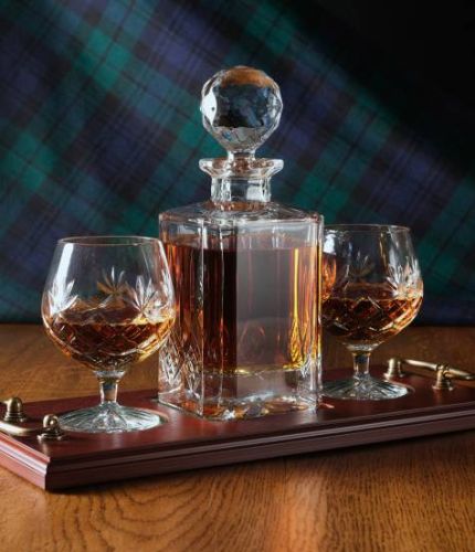 A 24% lead crystal panel cut square decanter and two full cut brandy goblets on a serving tray. We can offer a personalised engraving on the front of the decanter and an engraved brass plate on the wooden tray with this set.