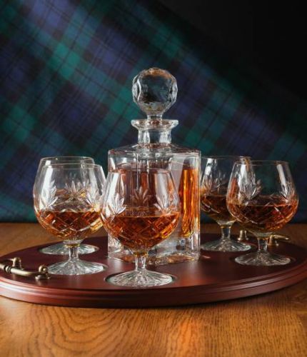 A 24% lead crystal panel cut square decanter and six fully cut brandy goblets on a serving tray. We can offer a personalised engraving on the front of the decanter and an engraved brass plate on the wooden tray with this set.