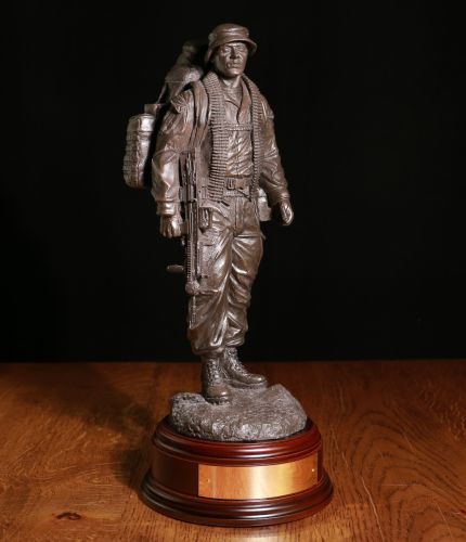 12" scale sculpture of a British Army Jungle Warfare soldier on patrol. We include this wooden base, a free badging service and an engraved brass plate as standard.