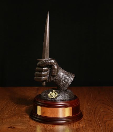 This is a 7" tall sculpture of a mailed fist holding a Sykes Dagger. Its the symbol of the Armour Support Groups of the Royal Marines. We offer a choice of bases, finishes and engraving options.