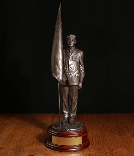 This is our 12" scale Male Standard Bearer. We can add your regimental cap badge to the base by his feet. We offer a choice of wooden bases and free engraving. 