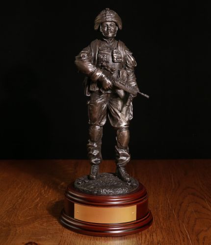 This is a 12" scale sculpture of a female British Army Soldier on an operational combat patrol. We include the wooden base as standard. You can also add a free cap badge and an optional engraved brass plate with this sculpture.