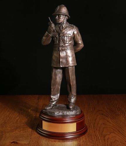 This presentation piece depicts a 'traditional' older style of British Police Constable on a daily foot patrol.  He's wearing the tunic style of uniform. The sculpture is 12 Inches tall and we include the standard wooden base and an engraved brass plate a