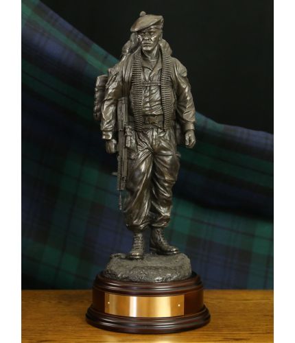 This is a Royal Regiment of Scotland infantry soldier. He's dressed in modern combat fatigues and is carrying his usual load of equipment and a belt of ammo for a GPMG. We include this wooden base as standard, and you can also add a badge and engraving pl