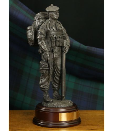 Cold bronze sculpture of a Royal Regiment of Scotland Mortar man. Wearing webbing and a rucksack, he has his SA80 in on hand and is holding the 81mm mortar barrel in the other. We include this base and a personalised brass engraved plate.