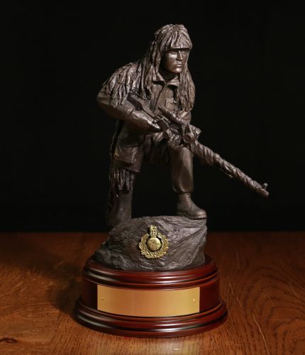 A cold cast 11" Scale bronze sculpture of a Royal Marine Sniper with an L96 Sniper Rifle. He's wearing a Ghillie Suit and is an ideal presentation piece and we include the engraved brass plate.