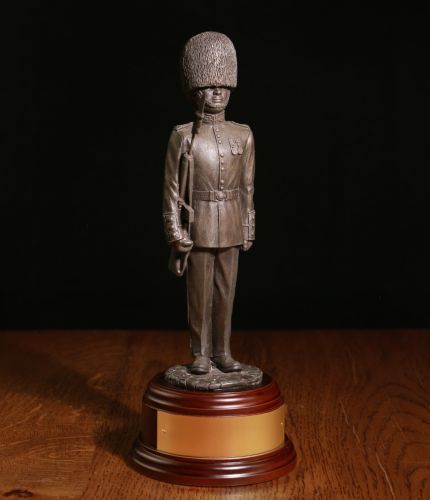 Bronze cold cast resin statuette of a Guardsman of The Scots Guards dressed in full parade dress with the distinctive red tunic and bearskin hat. He is armed the SLR rifle.