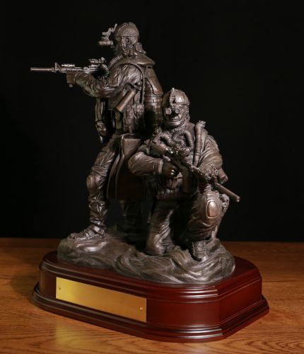 12" scale cold cast bronze resin sculpture of a pair of Special Forces Combat Swimmers. One is crouching and the other standing on the shoreline. We include the wooden base and an engraved brass plate with this figurine.