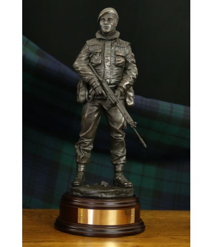 12" scale cold cast bronze resin sculpture of a soldier on Urban patrol in Northern Ireland during the Troubles. We include this wooden base, a free badging service and an engraved brass plate as standard.