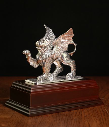 A handmade statue of a winged lion with a front paw raised. Cast in polished pewter this statue is the symbol of 37 (V) Signals Regiment and is used as a presentation piece for retirements and soldiers leaving the Unit. Every statue comes mounted on a woo